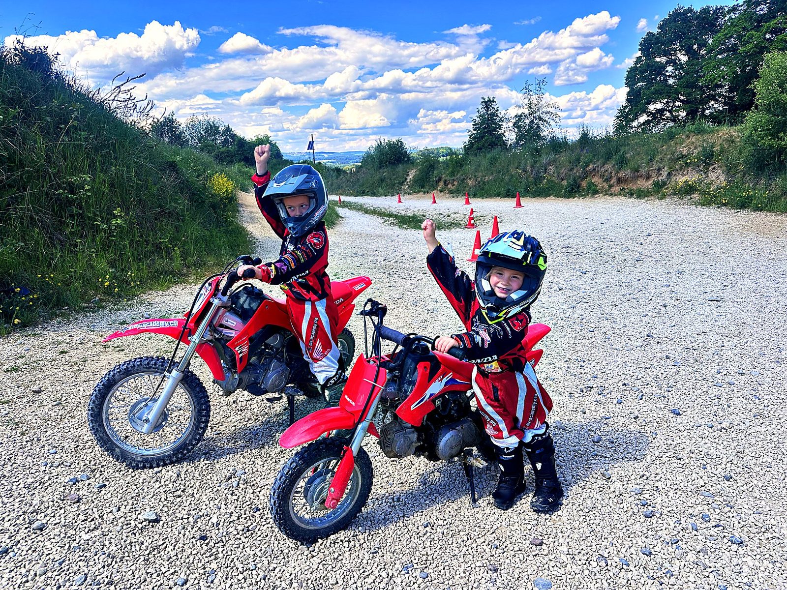 Kinder Motocross: Kinder auf Honda-Kindermotorrädern beim Start, ein Kind streckt den Arm in die Höhe